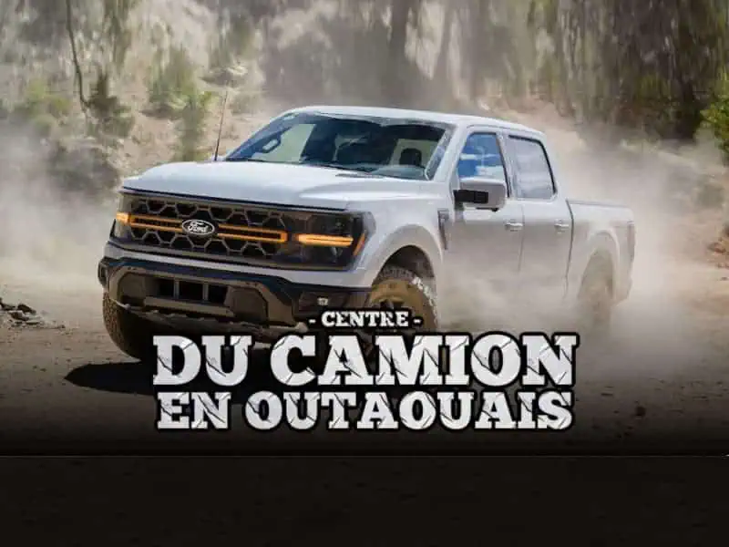 Un camion Ford blanc roule sur un chemin de terre, soulevant de la poussière.